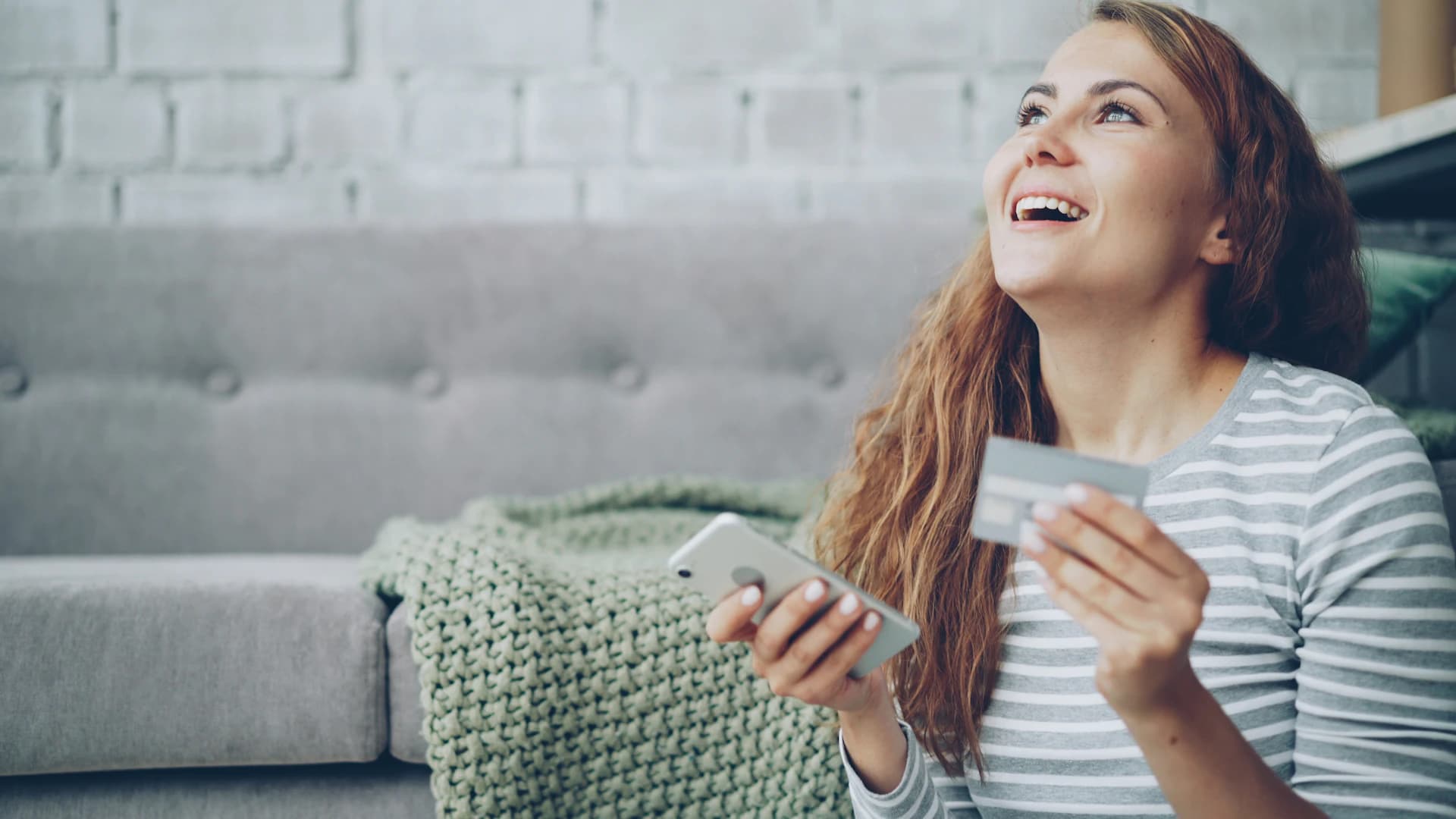 Eine lächelnde Frau bucht eine Wohnungsreinigung auf ihrem Handy